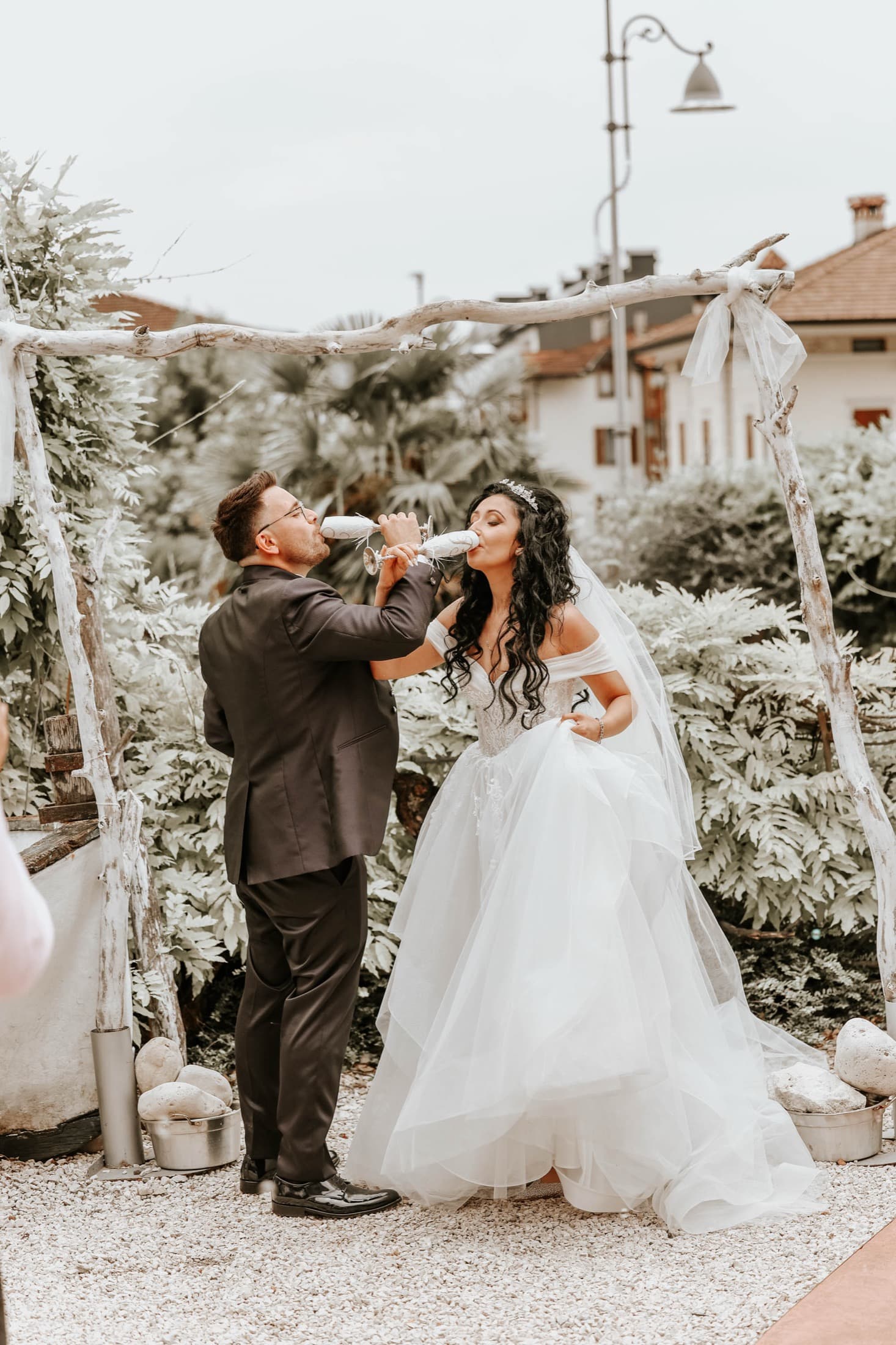Couple toasting under a floral arch
