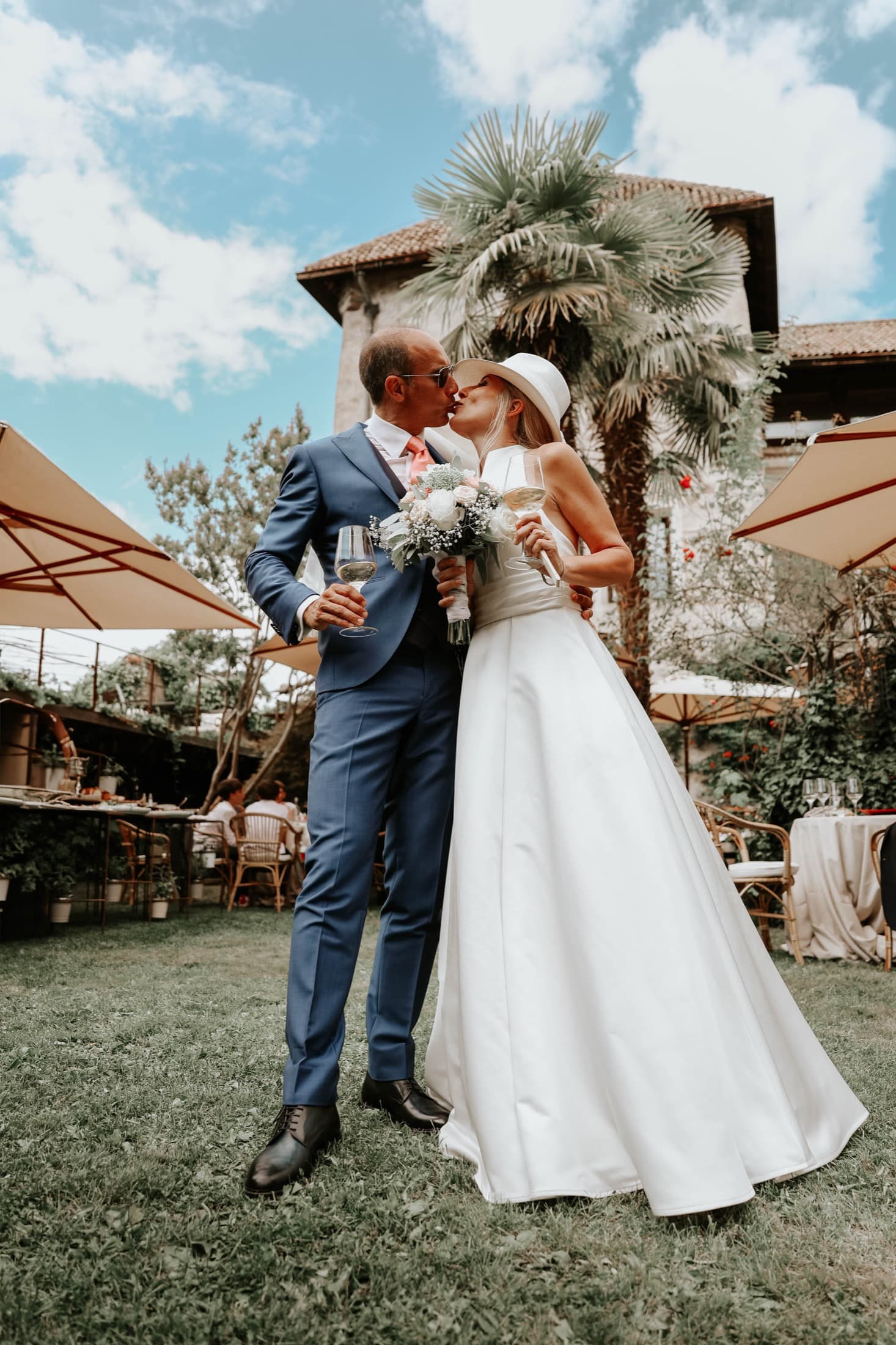 Newlyweds kissing in a villa garden