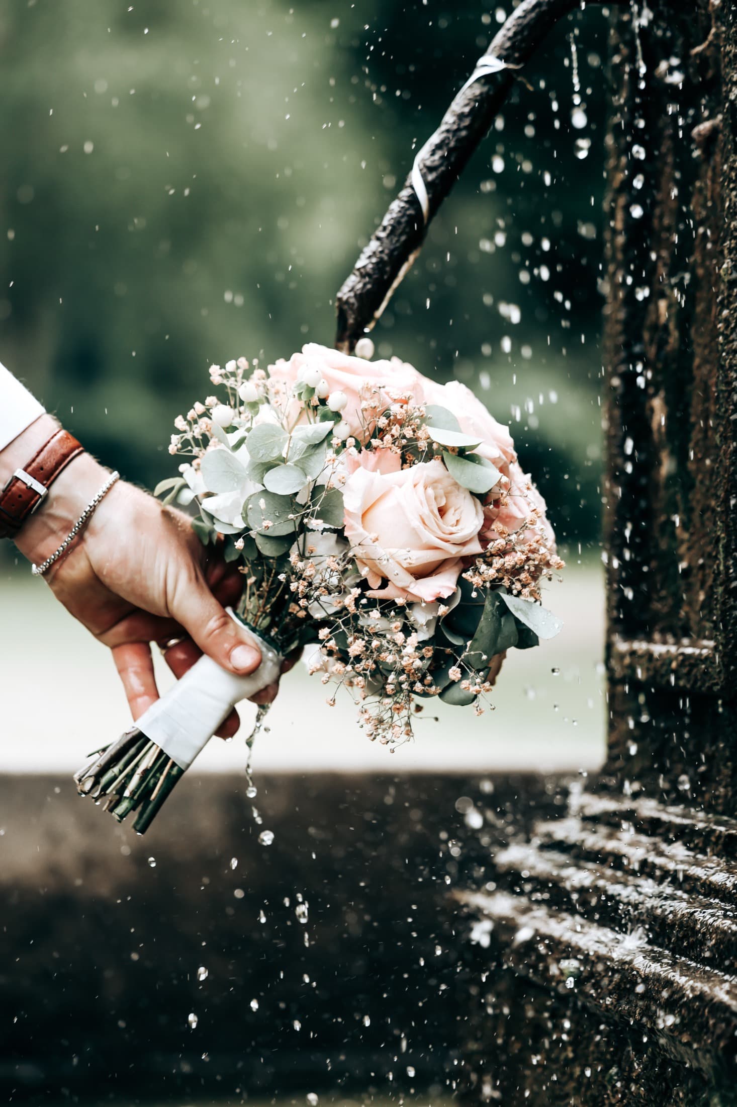 Bridal bouquet under fountain water spray