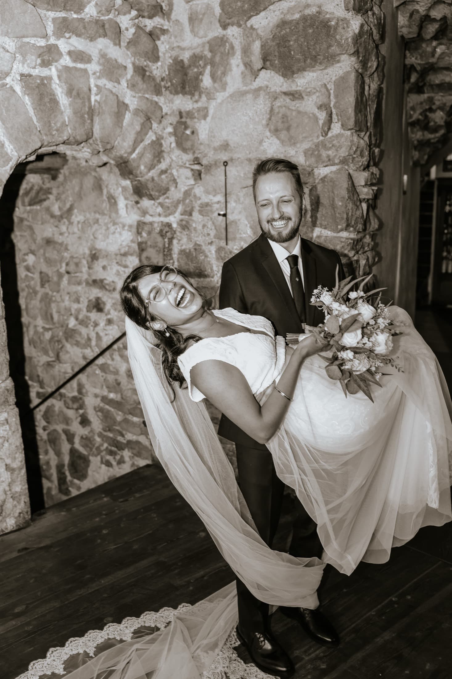 Groom carrying a laughing bride